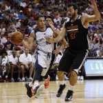 New Orleans Pelicans' Seth Curry passes around Phoenix Suns' Josh Harrellson during the first half of an NBA summer league basketball game Sunday, July 19, 2015, in Las Vegas. (AP Photo/John Locher)
