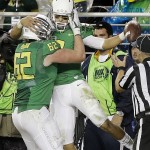 Oregon quarterback Marcus Mariota, right, is congratulated by Matt Pierson (62) after Mariota scored a touchdown against Arizona during the first half of a Pac-12 Conference championship NCAA college football game Friday, Dec. 5, 2014, in Santa Clara, Calif. (AP Photo/Ben Margot)