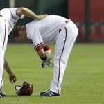  Arizona Diamondbacks' Aaron Hill, right, takes off his batting gloves in frustration as first base coach Dave McKay helps him with his batting helmet after Hill grounded out against the Milwaukee Brewers to end the fourth inning of a baseball game on Thursday, June 19, 2014, in Phoenix. (AP Photo/Ross D. Franklin)