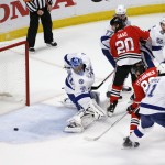Tampa Bay Lightning goalie Ben Bishop, left, watches as a puck slides wide of the net during the first period in Game 6 of the NHL hockey Stanley Cup Final series against the Chicago Blackhawks on Monday, June 15, 2015, in Chicago. (AP Photo/Charles Rex Arbogast)