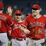 Los Angeles Angels' Mike Trout (27), Daniel Robertson (44) and third base coach Gary DiSarcina (9) celebrate a win against the Arizona Diamondbacks after a baseball game Thursday, June 18, 2015, in Phoenix. The Angels defeated the Diamondbacks 7-1. (AP Photo/Ross D. Franklin)