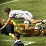 Germany's Thomas Mueller, top, falls over France's goalkeeper Hugo Lloris, right, during the World Cup quarterfinal soccer match between Germany and France at the Maracana Stadium in Rio de Janeiro, Brazil, Friday, July 4, 2014. (AP Photo/Thanassis Stavrakis)
