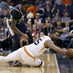 Phoenix Suns' Marcus Morris saves the ball from going out of bounds as Utah Jazz forward Trevor Booker defends during the first half of an NBA basketball game, Saturday, April 4, 2015, in Phoenix. (AP Photo/Matt York)
