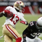 San Francisco 49ers wide receiver Steve Johnson (13) tries to avoid Arizona Cardinals cornerback Jerraud Powers (25) during the second half of an NFL football game, Sunday, Sept. 21, 2014, in Glendale, Ariz. (AP Photo/Ross D. Franklin)