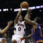Atlanta Hawks' Jeff Teague, center, puts up a shot against Phoenix Suns' Markieff Morris, left, and Eric Bledsoe in the second quarter of an NBA basketball game Tuesday, April 7, 2015, in Atlanta. The Hawks set a single-season franchise high with their 58th victory, getting 16 points each from Teague and DeMarre Carroll in a 96-69 win. (AP Photo/David Goldman)