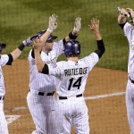 Colorado Rockies' Michael Cuddyer, second from left, celebrates hitting a grand slam with teammates Charlie Blackmon, left, Josh Rutledge (14) and Justin Morneau, right, in the sixth inning of a baseball game against the Arizona Diamondbacks, Friday, Sept. 19, 2014, in Denver. (AP Photo/Chris Schneider)