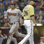 Arizona Diamondbacks' Aaron Hill, left, scores as Milwaukee Brewers starting pitcher Kyle Lohse watches his own throwing error on a bunt by Diamondbacks' Chris Owings during the second inning of a baseball game Saturday, May 30, 2015, in Milwaukee. (AP Photo/Jeffrey Phelps)