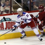 New York Rangers center Derek Stepan (21) shields Arizona Coyotes defenseman Keith Yandle from the puck during the second period during an NHL hockey game, Saturday, Feb. 14, 2015, in Glendale, Ariz. (AP Photo/Rick Scuteri)