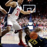 Michigan guard Caris LeVert (23) grabs the loose ball in front of Arizona guard Elliott Pitts (24) during the first half of an NCAA college basketball game, Saturday, Dec. 13, 2014, in Tucson, Ariz. (AP Photo/Rick Scuteri)