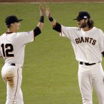 San Francisco Giants' Joe Panik, left, and Brandon Crawford high five after Game 4 of baseball's World Series against the Kansas City Royals on Saturday, Oct. 25, 2014, in San Francisco. The Giants won the game 11-4 to tie the series 2-2. (AP Photo/Charlie Riedel)
