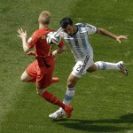 Argentina's Ezequiel Garay, right, and Belgium's Kevin De Bruyne fight for the ball during the World Cup quarterfinal soccer match between Argentina and Belgium at the Estadio Nacional in Brasilia, Brazil, Saturday, July 5, 2014. (AP Photo/Thanassis Stavrakis)