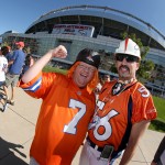 In this photo taken with a fisheye lens, Denver Broncos fans' Jay James, from Arizona, and Thomas Leypa cheer for the team prior to an NFL football game against the Arizona Cardinals, Sunday, Oct. 5, 2014, in Denver. (AP Photo/David Zalubowski)