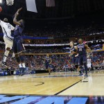  Villanova's JayVaughn Pinkston (22) shoots over Connecticut's Amida Brimah (35) during the first half of a third-round game in the NCAA men's college basketball tournament in Buffalo, N.Y., Saturday, March 22, 2014. (AP Photo/Bill Wippert)