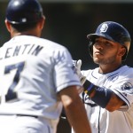 San Diego Padres' Alexi Amarista claps his hands as first base coach Jose Valentin congratulates him after his run producing single against the Arizona Diamondbacks in the fourth inning of a baseball game Monday, Sept. 1, 2014, in San Diego. (AP Photo/Lenny Ignelzi)

