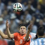 Netherlands' Robin van Persie eyes the ball during the World Cup semifinal soccer match between the Netherlands and Argentina at the Itaquerao Stadium in Sao Paulo Brazil, Wednesday, July 9, 2014. (AP Photo/Martin Meissner)