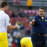 Michigan coach Brady Hoke walks among his players as they prepare for an NCAA college football game against Rutgers on Saturday, Oct. 4, 2014, in Piscataway, N.J. (AP Photo/Rich Schultz)