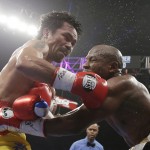 Manny Pacquiao, from the Philippines, left, trades blows with Floyd Mayweather Jr., during their welterweight title fight on Saturday, May 2, 2015 in Las Vegas. (AP Photo/Isaac Brekken)