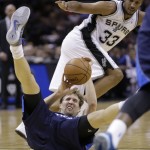 Dallas Mavericks' Dirk Nowitzki, bottom, of Germany, falls to the floor as he and San Antonio Spurs' Boris Diaw (33), of France, chase a loose ball during the first half of Game 2 of the opening-round NBA basketball playoff series on Wednesday, April 23, 2014, in San Antonio. (AP Photo/Eric Gay)