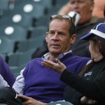 Colorado Rockies co-owner Dick Monfort, left, chats with a woman while sitting in the stands to watch his team host the Arizona Diamondbacks in the first inning of the second game of a baseball doubleheader, Wednesday, May 6, 2015, in Denver. (AP Photo/David Zalubowski)