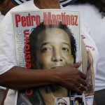 A Pedro Martinez fan carries a poster at the Clark Sports Center before the National Baseball Hall of Fame induction ceremony on Sunday, July 26, 2015, in Cooperstown, N.Y. Martinez will be inducted to the hall Sunday afternoon. (AP Photo/Mike Groll)
