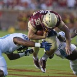 Florida State's Nick O'Leary dives for yardage as The Citadel's DeVonta Delaney, right, and Rah Muhammad make the tackle in the first quarter of an NCAA college football game Saturday, Sept. 6, 2014, in Tallahassee, Fla. (AP Photo/Steve Cannon)