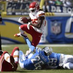 Kansas City Chiefs running back Jamaal Charles, top, leaps over San Diego Chargers cornerback Brandon Flowers (26) and inside linebacker Andrew Gachkar, right, during the first half of an NFL football game Sunday, Oct. 19, 2014, in San Diego. (AP Photo/Denis Poroy)