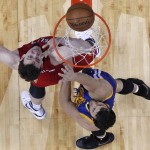 New Orleans Pelicans center Omer Asik shoots against Golden State Warriors center Andrew Bogut (12) during the first half of Game 3 of a first-round NBA basketball playoff series in New Orleans, Thursday, April 23, 2015. (AP Photo/Gerald Herbert)