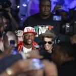 Floyd Mayweather Jr., center left, is joined by Justin Bieber as he enters the area for his WBC-WBA welterweight title boxing fight against Marcos Maidana Saturday, May 3, 2014, in Las Vegas. (AP Photo/Isaac Brekken)