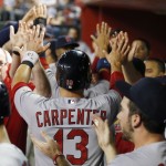 St. Louis Cardinals' Matt Carpenter (13) gets high-fives from teammates after he scored a run against the Arizona Diamondbacks during the sixth inning of a baseball game Friday, Sept. 26, 2014, in Phoenix. (AP Photo/Ross D. Franklin)