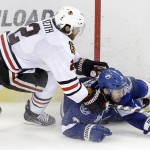 Tampa Bay Lightning center Tyler Johnson (9) hits the ice as he fights for control of the puck against Chicago Blackhawks defenseman Duncan Keith (2) during the third period of Game 5 of the NHL hockey Stanley Cup Final, Saturday, June 13, 2015, in Tampa, Fla. The Blackhawks won 2-1. (AP Photo/John Raoux)