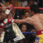 Manny Pacquiao, from the Philippines, right, hits Floyd Mayweather Jr., during their welterweight title fight on Saturday, May 2, 2015 in Las Vegas. (AP Photo/Eric Jamison)