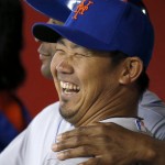 New York Mets pitcher Daisuke Matsuzaka, front, of Japan, laughs as he jokes with coach Tom Goodwin, back in the dugout prior to the MLB National League baseball game against the Arizona Diamondbacks on Wednesday, April 16, 2014, in Phoenix. (AP Photo/Ross D. Franklin)