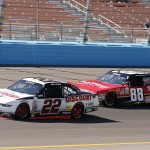 Joey Logano (22) takes the lead over Kevin Harvick in the second lap during the NASCAR Xfinity Series auto race on Saturday, March 14, 2015, in Avondale, Ariz. (AP Photo/Rick Scuteri)