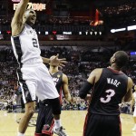 San Antonio Spurs forward Tim Duncan dunks as Miami Heat guard Dwyane Wade (3) looks on during the first half in Game 2 of the NBA basketball finals on Sunday, June 8, 2014, in San Antonio. (AP Photo/Eric Gay)
