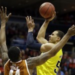  Michigan forward Jordan Morgan, right, takes a shot against Texas center Prince Ibeh during the second half of a third-round game of the NCAA college basketball tournament Saturday, March 22, 2014, in Milwaukee. (AP Photo/Jeffrey Phelps)