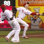 Philadelphia Phillies second baseman Chase Utley, right makes a catch in foul territory against Arizona Diamondbacks' Yasmany Tomas with first baseman Ryan Howard, left, getting out of the way during the fourth inning of a baseball game, Saturday, May 16, 2015, in Philadelphia. (AP Photo/Chris Szagola)