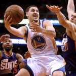 Golden State Warriors guard Klay Thompson (11) drives between Phoenix Suns forward Marcus Morris (15) and Alex Len in the first quarter during an NBA basketball game, Monday, March 9, 2015, in Phoenix. (AP Photo/Rick Scuteri)