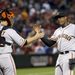 San Francisco Giants' Santiago Casilla, right, celebrates with catcher Buster Posey, left, after the final out against the Arizona Diamondbacks in the ninth inning of an opening day baseball game Monday, April 6, 2015, in Phoenix. The Giants won 5-4. (AP Photo/Ross D. Franklin)