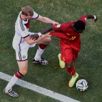 Germany's Per Mertesacker, left, grabs the arm of Ghana's Sulley Muntari as he attempts to tackle during the group G World Cup soccer match between Germany and Ghana at the Arena Castelao in Fortaleza, Brazil, Saturday, June 21, 2014. (AP Photo/Francois Xavier Marit, pool)