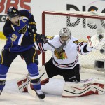 Chicago Blackhawks' goalie Corey Crawford, right, makes a glove-save against St. Louis Blues' David Backes (42) during the second period in Game 2 of a first-round NHL hockey playoff series on Saturday, April 19, 2014, in St. Louis. (AP Photo/Bill Boyce)