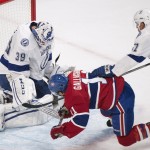 Montreal Canadiens' Brendan Gallagher, center, moves in on Tampa Bay Lightning's goalie Anders Lindback , left, as Lightning's Valtteri Filppula defends during first period of the first round NHL Stanley Cup playoff action in Montreal, Sunday, April 20, 2014. (AP Photo/The Canadian Press, Grhaham Hughes)