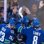 Vancouver Canucks' Nick Bonino is mobbed by his teammates after scoring against the Calgary Flames during the second period of Game 5 of an NHL hockey first-round playoff series, Thursday, April 23, 2015, in Vancouver, British Columbia. (Darryl Dyck/The Canadian Press via AP)