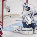 Montreal Canadiens' Rene Bourque, left, scores against Tampa Bay Lightning's goalie Anders Lindback during first period of the first round NHL Stanley Cup playoff game in Montreal, Sunday, April 20, 2014. (AP Photo/The Canadian Press, Graham Hughes)