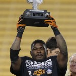 Oklahoma State running back Desmond Roland holds the offensive MVP trophy after the Cactus Bowl NCAA college football game against Washington, Friday, Jan. 2, 2015, in Tempe, Ariz. Oklahoma State won 30-22. (AP Photo/Rick Scuteri)