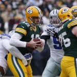 Green Bay Packers quarterback Aaron Rodgers (12) is sacked by Dallas Cowboys defensive end Jeremy Mincey (92) during the first half of an NFL divisional playoff football game Sunday, Jan. 11, 2015, in Green Bay, Wis. (AP Photo/Mike Roemer)