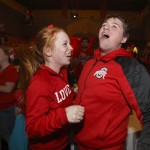 Ohio State fans Jennifer Bennett, left, of Canton, Ohio, and Andrew Denkus of Stamford, Conn., react to a play while watching the National Championship football game between Ohio State and Oregon on the campus of Ohio State University in Columbus, Ohio, Monday, Jan. 12, 2015. (AP Photo/Paul Vernon)