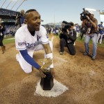 Kansas City Royals' Jarrod Dyson puts the championship trophy on home plate after the Royals defeated the Baltimore Orioles to win the American League baseball championship series Wednesday, Oct. 15, 2014, in Kansas City, Mo. (AP Photo/Charlie Riedel)