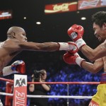 Floyd Mayweather Jr., left, reaches and connects with his right against Manny Pacquiao, from the Philippines, during their welterweight title fight on Saturday, May 2, 2015 in Las Vegas. (AP Photo/Isaac Brekken)