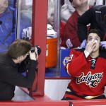 Calgary Flames' Johnny Gaudreau, right, gets attended to after taking a stick to the face during the first period of an NHL hockey game against the Arizona Coyotes, Tuesday, April 7, 2015 in Calgary, Alberta. (AP Photo/The Canadian Press, Larry MacDougal)
