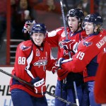 Washington Capitals right wing Tom Wilson, center, celebrates his goal with defenseman Nate Schmidt (88) and center Nicklas Backstrom (19), from Sweden, in the first period of an NHL hockey game against the Arizona Coyotes, Sunday, Nov. 2, 2014, in Washington. (AP Photo/Alex Brandon)